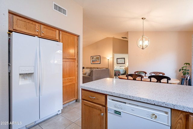 kitchen featuring an inviting chandelier, light tile patterned floors, white appliances, light stone countertops, and pendant lighting