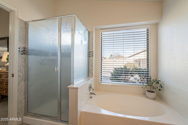 bathroom with plenty of natural light and separate shower and tub