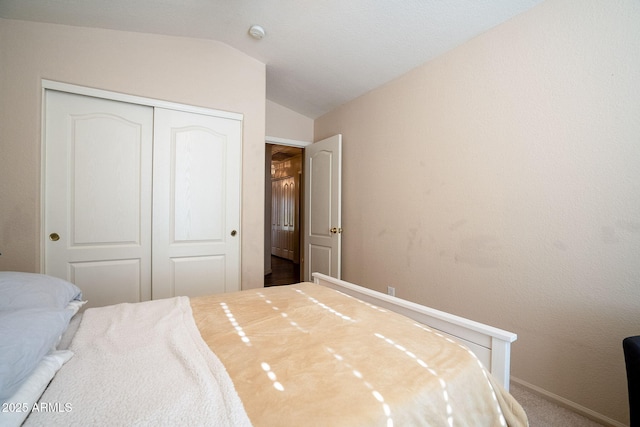 bedroom with carpet floors, a closet, and vaulted ceiling