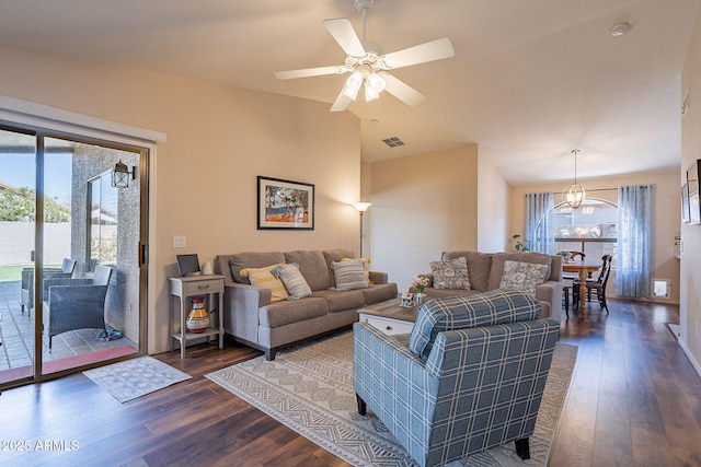 living room featuring dark hardwood / wood-style flooring, a wealth of natural light, and ceiling fan with notable chandelier