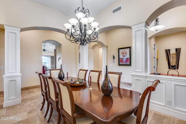 dining room with ceiling fan with notable chandelier, vaulted ceiling, and ornate columns