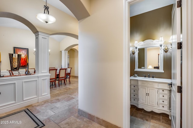 hallway with sink and ornate columns