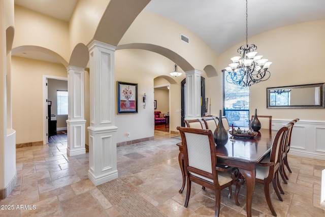 dining area featuring ornate columns and high vaulted ceiling