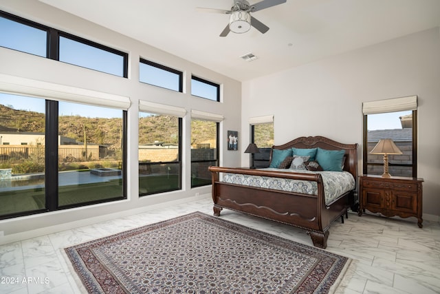 bedroom with a ceiling fan, marble finish floor, visible vents, and multiple windows