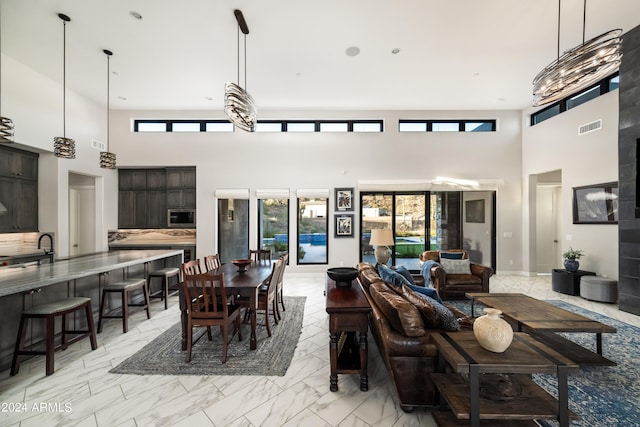 living room featuring marble finish floor, visible vents, and a high ceiling