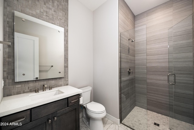 bathroom with toilet, vanity, baseboards, marble finish floor, and a shower stall