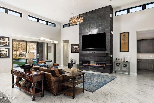 living area featuring marble finish floor, a fireplace, a wealth of natural light, and baseboards