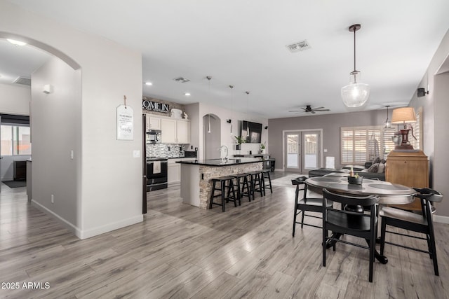 dining area featuring ceiling fan, a healthy amount of sunlight, and light wood-type flooring