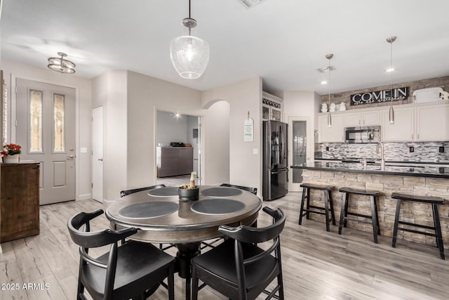 dining area with sink and light hardwood / wood-style floors