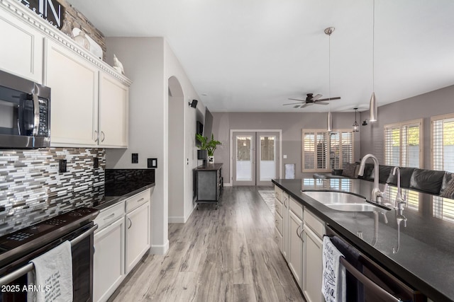 kitchen with sink, white cabinetry, tasteful backsplash, stainless steel electric range oven, and hanging light fixtures