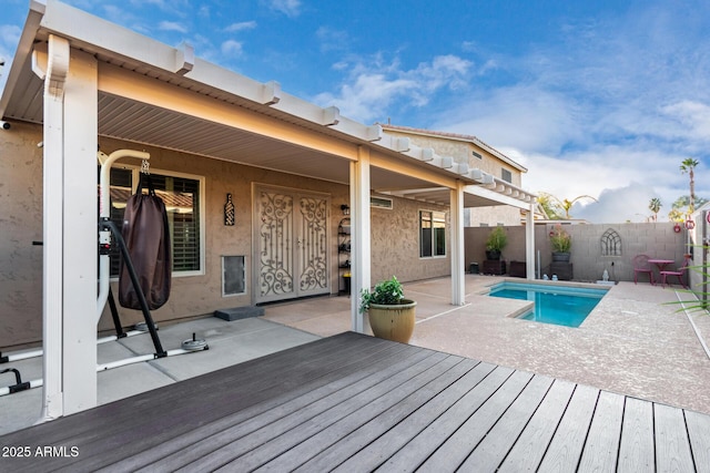 back of house featuring a swimming pool side deck and a patio