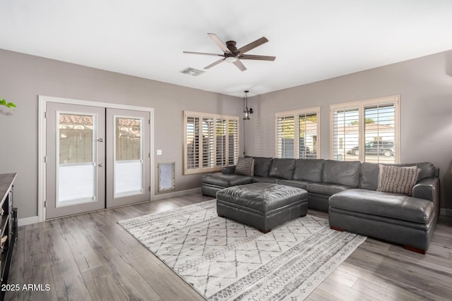 living room with french doors, ceiling fan, and light hardwood / wood-style flooring