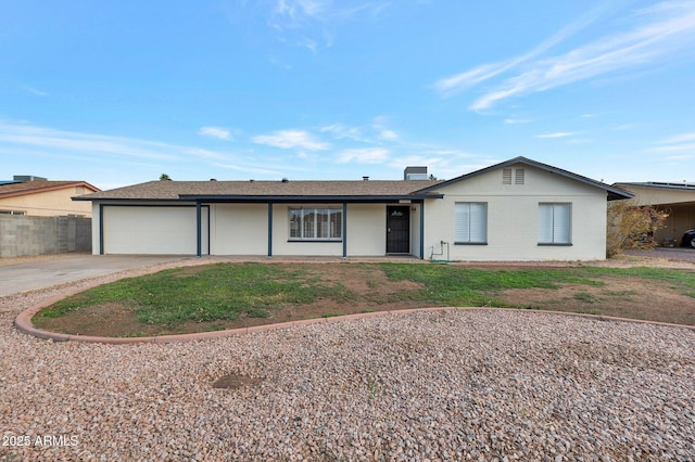 ranch-style home featuring an attached garage, concrete driveway, and fence