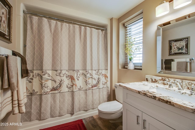 full bathroom with hardwood / wood-style flooring, vanity, shower / bath combination with curtain, and toilet