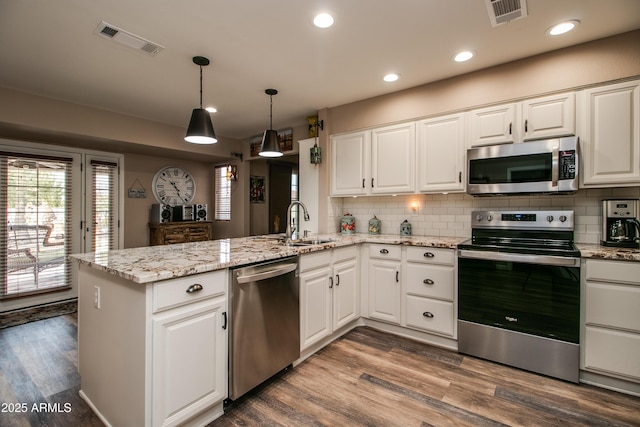 kitchen with white cabinetry, appliances with stainless steel finishes, and kitchen peninsula