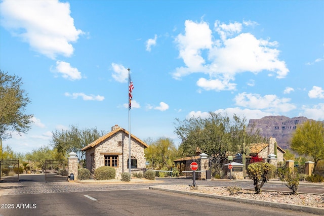 7846 E Wilderness Trl, Gold Canyon, AZ 85118 - view of asphalt street featuring curbs, traffic signs, and a gated entry