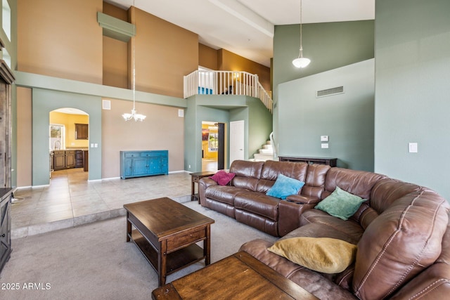 tiled living room featuring visible vents, a high ceiling, carpet flooring, and stairs