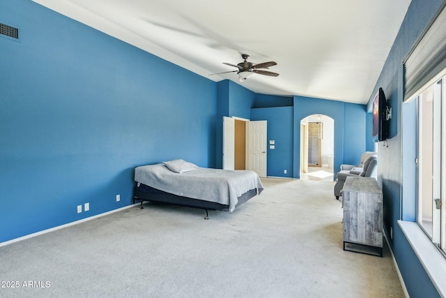 bedroom featuring visible vents, baseboards, carpet floors, arched walkways, and a ceiling fan