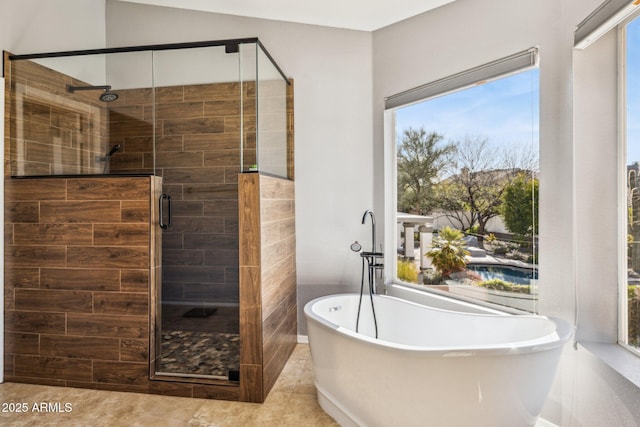 bathroom featuring tile patterned flooring, a shower stall, and a freestanding bath