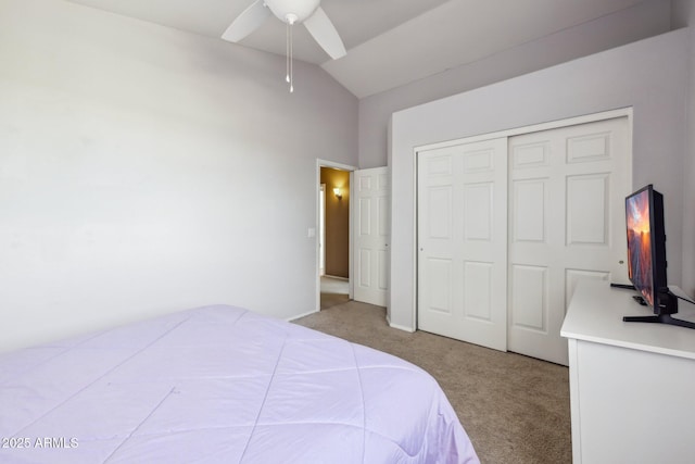 bedroom with a closet, a ceiling fan, carpet, and vaulted ceiling