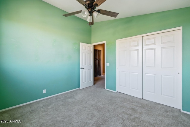 unfurnished bedroom with vaulted ceiling, carpet, a closet, and baseboards