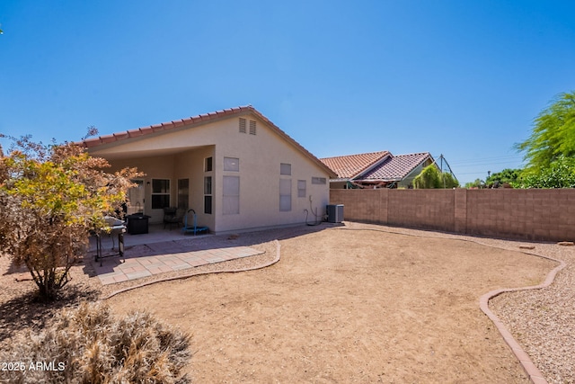 back of property with a tile roof, a patio area, stucco siding, and a fenced backyard