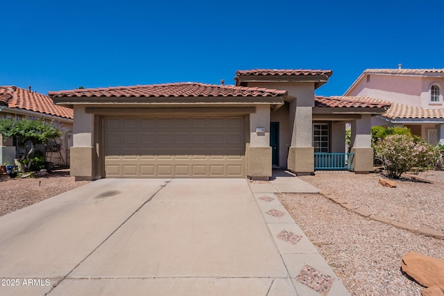 mediterranean / spanish-style house featuring concrete driveway, stucco siding, a garage, and a tiled roof