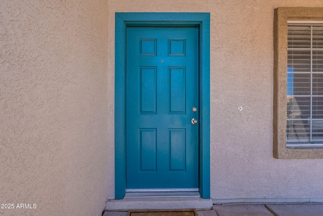 view of exterior entry with stucco siding