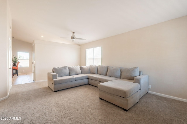 living area with light carpet, plenty of natural light, a ceiling fan, baseboards, and vaulted ceiling