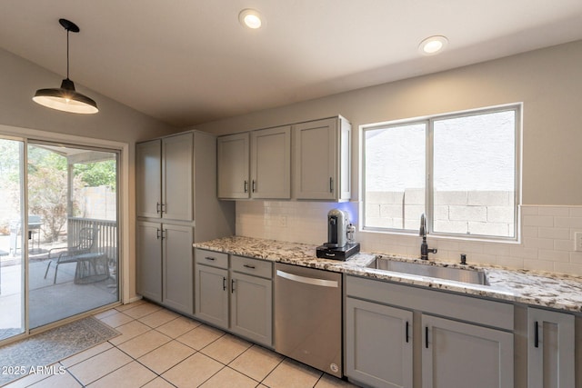 kitchen featuring dishwasher, gray cabinets, a sink, backsplash, and light tile patterned floors