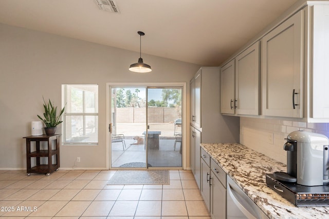 doorway featuring lofted ceiling, light tile patterned flooring, and baseboards