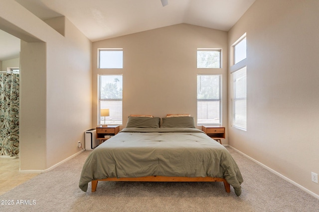 bedroom with lofted ceiling, light colored carpet, and baseboards