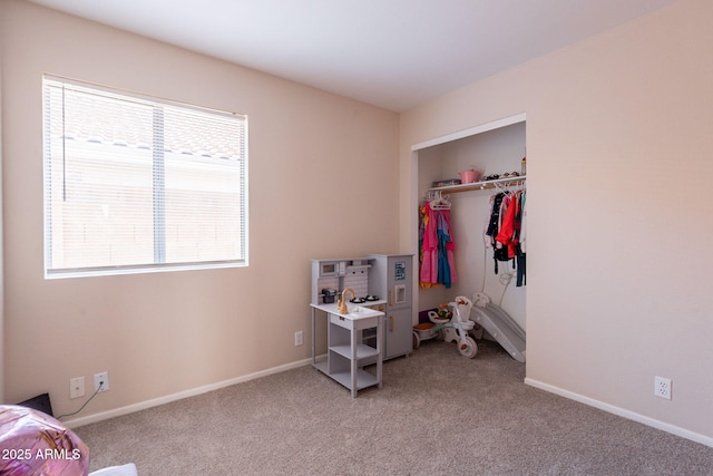 bedroom featuring multiple windows, light carpet, baseboards, and a closet