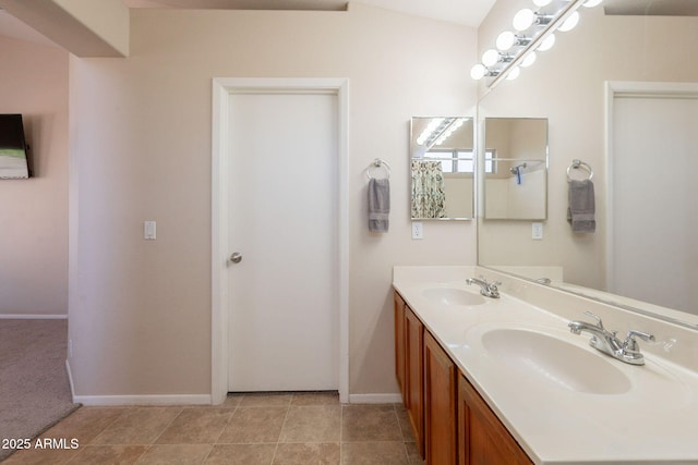full bath featuring baseboards and double vanity