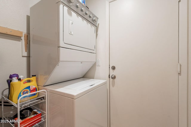clothes washing area with stacked washer / dryer