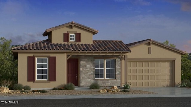mediterranean / spanish-style home with stucco siding, an attached garage, stone siding, a tiled roof, and driveway