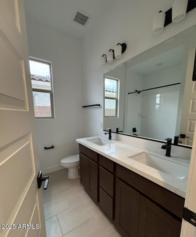 16994 W Canterbury Dr, Surprise, AZ 85388 - full bath with toilet, tile patterned floors, a shower, double vanity, and baseboards