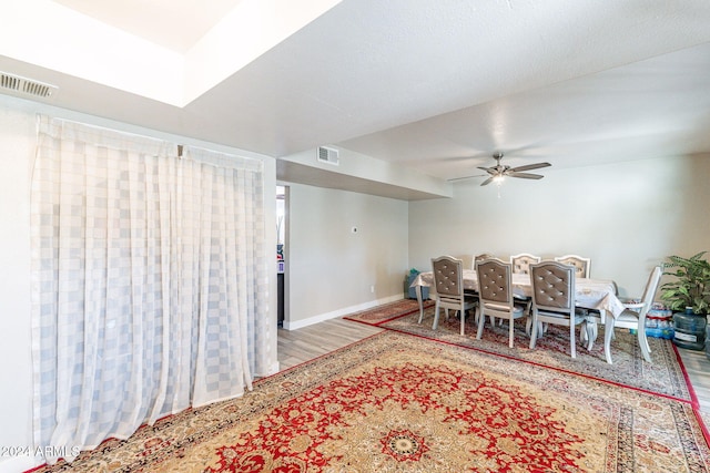 dining space with ceiling fan and wood-type flooring