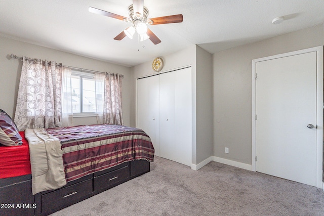 carpeted bedroom featuring ceiling fan and a closet