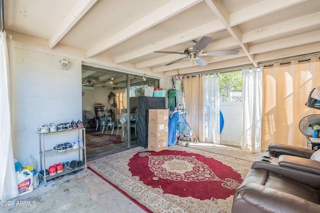 living room with beamed ceiling, ceiling fan, and concrete flooring