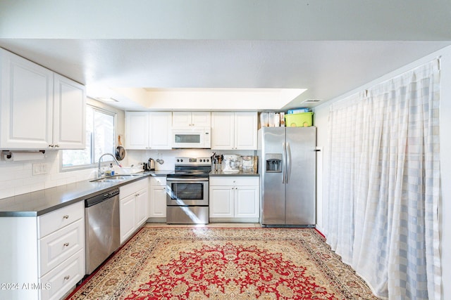 kitchen featuring white cabinetry, sink, stainless steel appliances, and tasteful backsplash