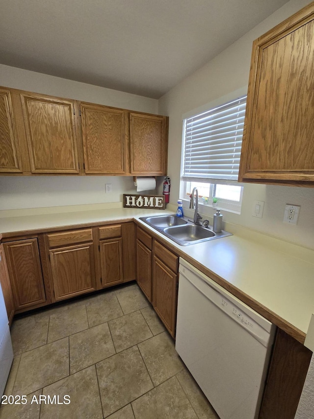 kitchen featuring sink, white dishwasher, and light tile patterned floors