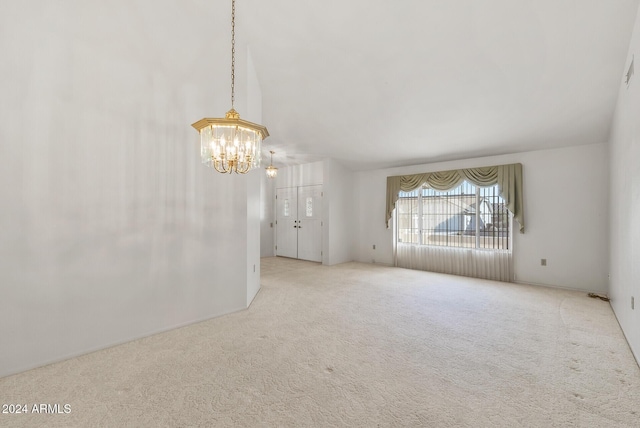 empty room with a chandelier and light colored carpet