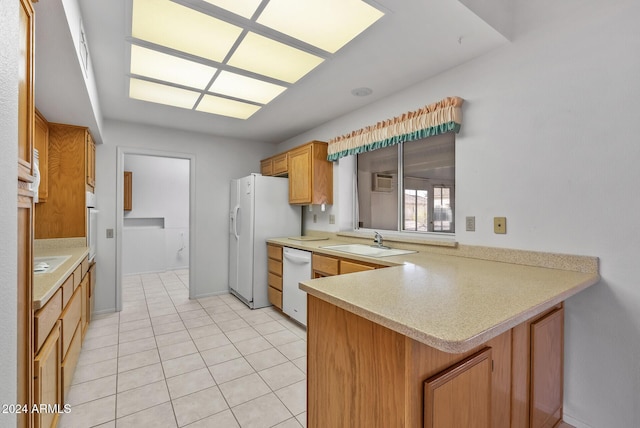 kitchen featuring kitchen peninsula, white appliances, light tile patterned flooring, and sink