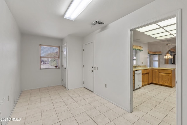 tiled empty room featuring ceiling fan, plenty of natural light, and sink