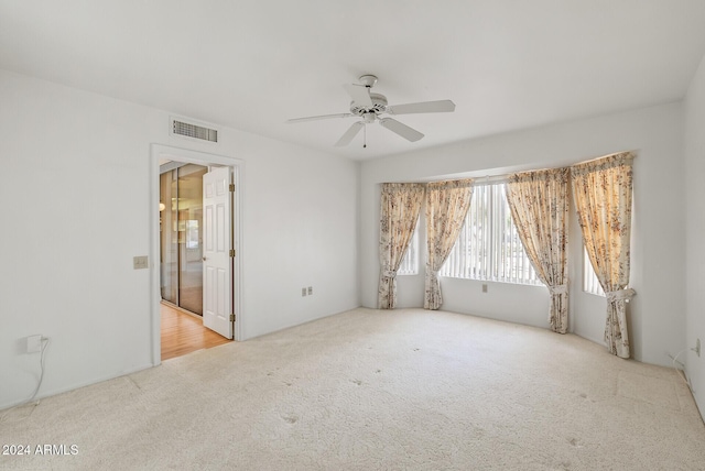 unfurnished room featuring light carpet and ceiling fan