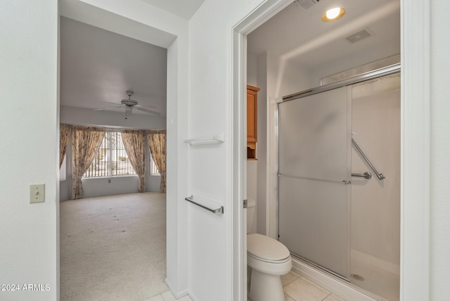 bathroom with tile patterned flooring, ceiling fan, toilet, and walk in shower