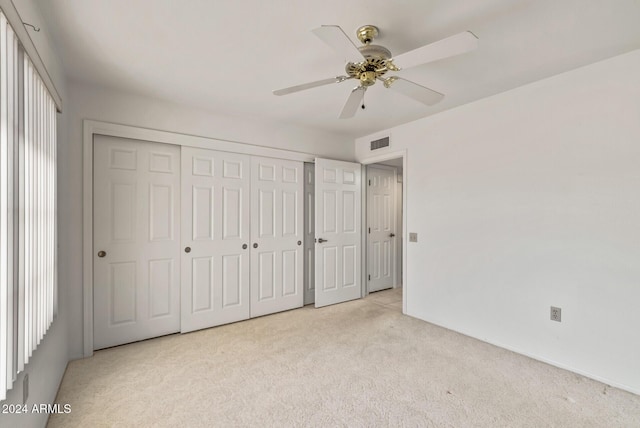 unfurnished bedroom with ceiling fan and light colored carpet