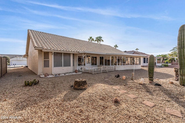 rear view of property featuring a sunroom