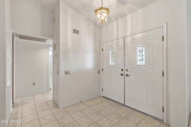 tiled entryway featuring an inviting chandelier